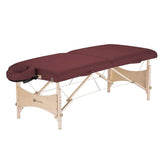 A red-covered portable massage table, ready for a relaxing massage session in a tranquil setting.